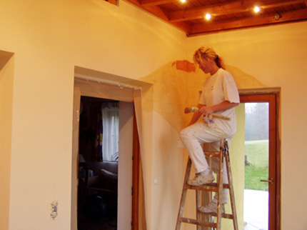 Malermeisterin Sebela auf einer Leiter stehend.